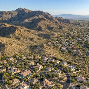 Aerial drone view of Ahwatukee, Arizona, with suburban rooftops set against the desert slopes of South Mountain.