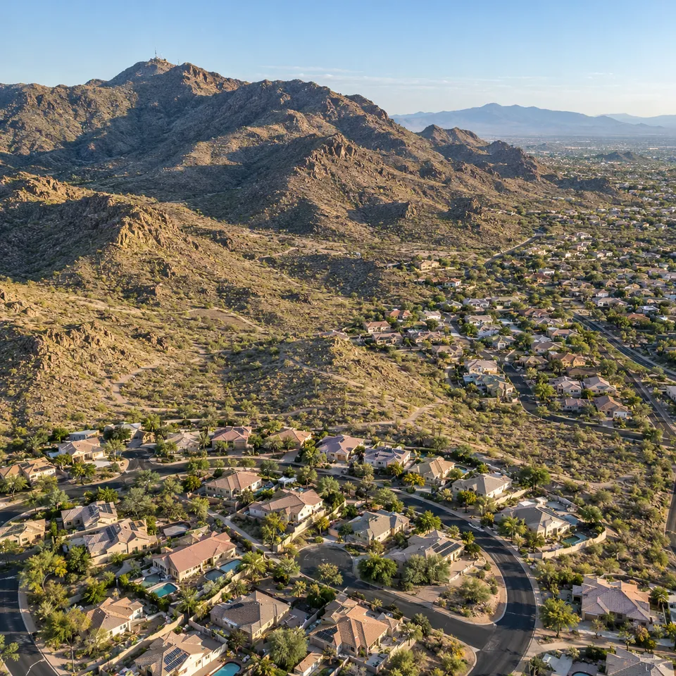 Aerial drone view of Ahwatukee, Arizona, with suburban rooftops set against the desert slopes of South Mountain.
