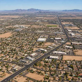 Aerial drone view of an established residential grid in El Mirage, Arizona, bordering open desert and farmland.