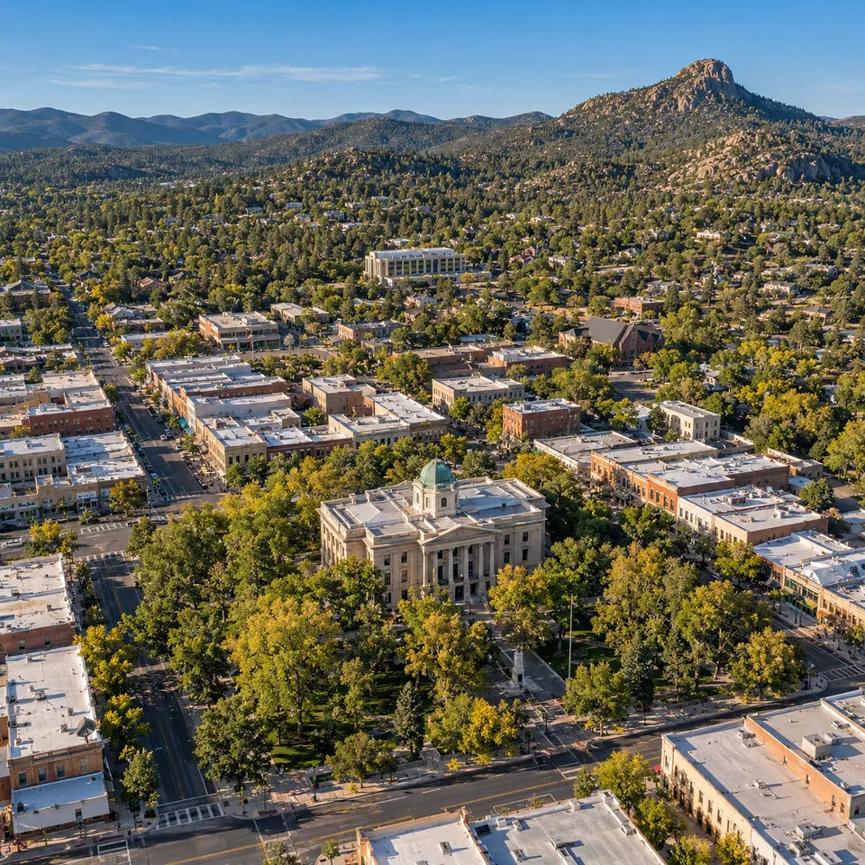 Aerial drone view of the historic Yavapai County Courthouse Plaza in downtown Prescott, Arizona, with granite peaks beyond.