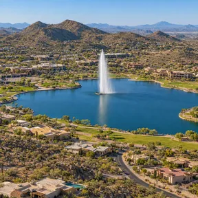 Aerial drone view of the iconic Fountain Hills fountain shooting into the air above its lake in Fountain Hills, Arizona.