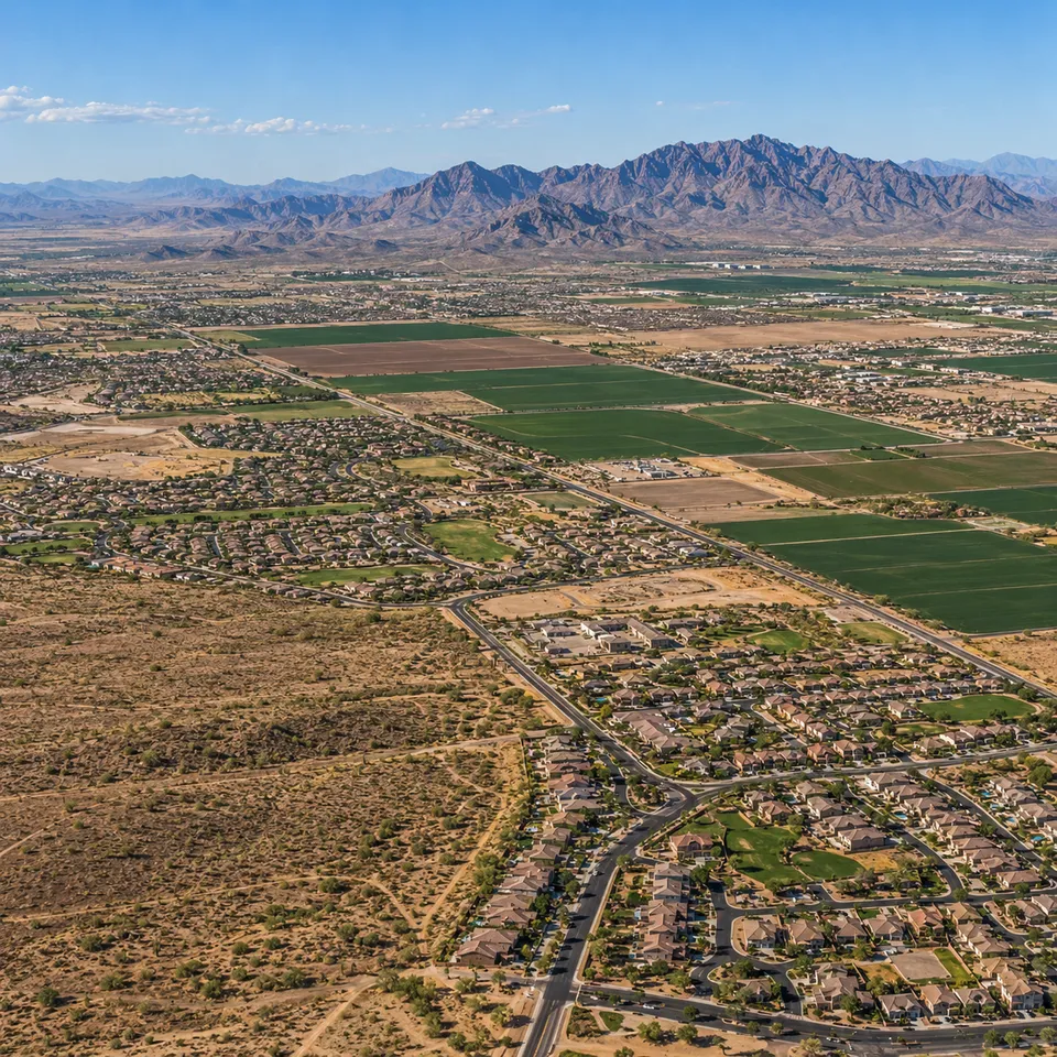 Aerial drone view of a new housing subdivision at the edge of open desert in Buckeye, Arizona.