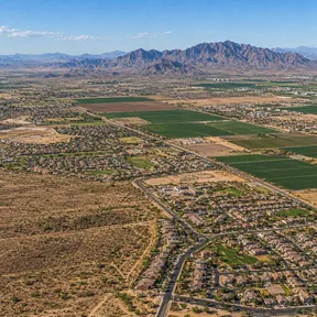 Aerial drone view of a new housing subdivision at the edge of open desert in Buckeye, Arizona.