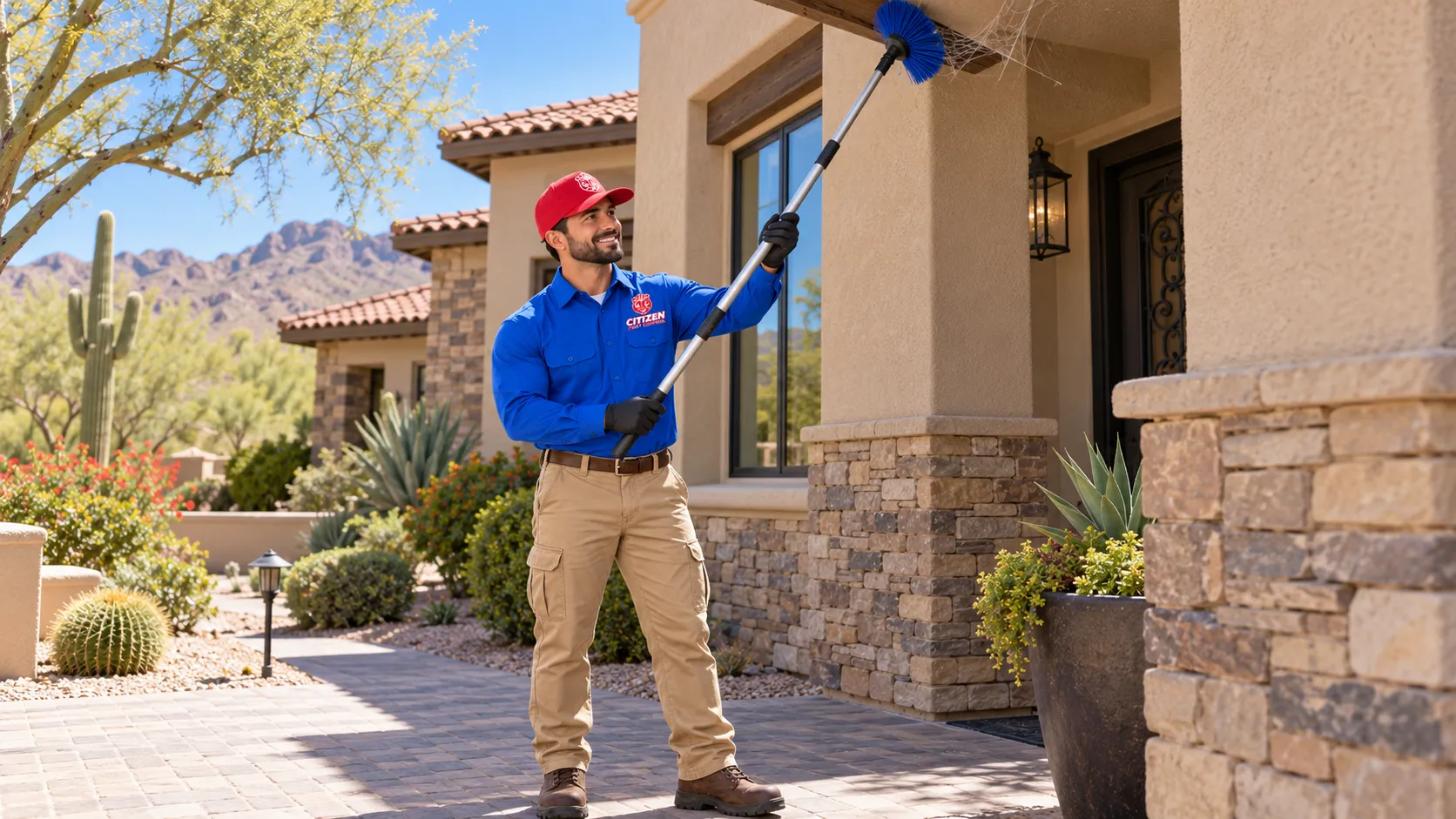 A Heritage Pest Control technician clearing a spider web from a home's eaves with an extension duster